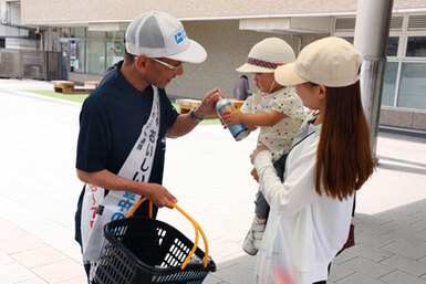 母子に備蓄水を手渡す吉田管理者