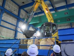 掘削土砂をすくうバックホウ