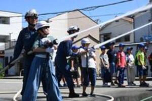 消防吏員と放水体験をする写真