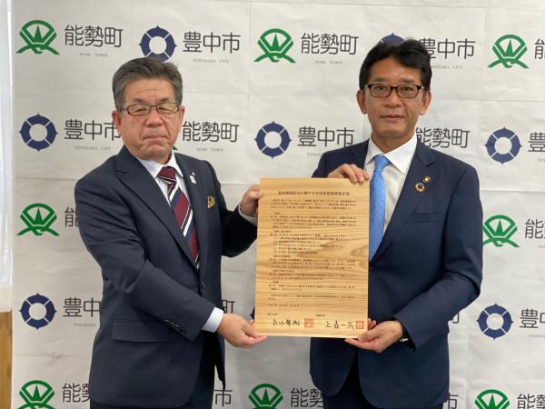 協定書を手に持つ長内市長と上森町長